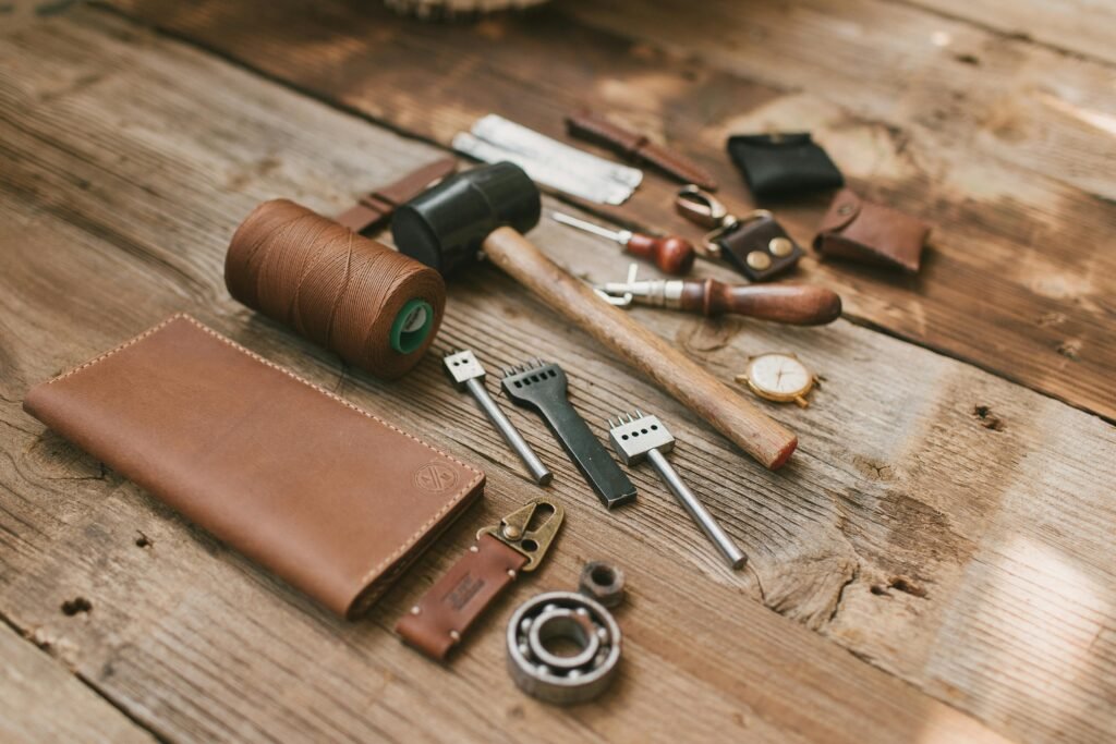 A collection of leather crafting tools neatly arranged on a wooden surface, emphasizing traditional craftsmanship.